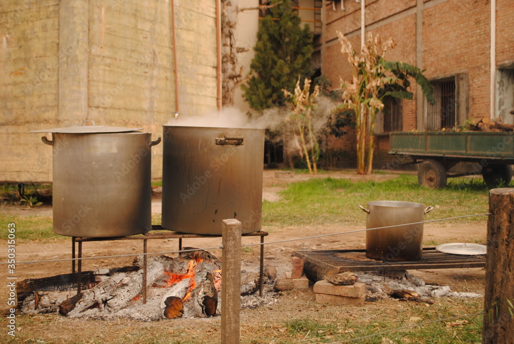 Outdoor Cooking a stew in old rusty bucket or cooking pot or pan Outdoor Cooking a stew in old rusty bucket or cooking pot or pan