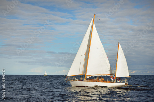Old expensive vintage two-masted sailboat (yawl) close-up, sailing in an open sea. Coast of Maine, US. Sport, cruise, tourism, recreation, leisure activity, transportation, nautical vessel	