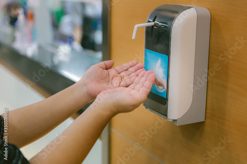 Hands under the automatic alcohol dispenser. Infection and hospitably concept. save and protect disease virus against germs and clean in the public area. 