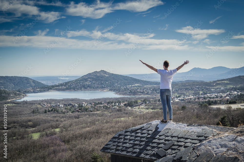 young man standing on top of house, montains young man standing on top of house, montains