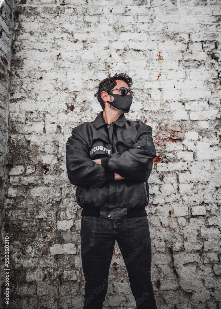 Male security person in black security outfil and black face mask Male security person in black security outfil and black face mask
