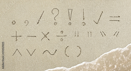 Punctuation mark handwritten in the sand on the beach photo