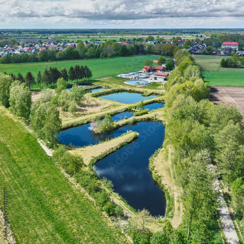 Aerial view of the meandering secondary clarifier at the end of a village sewage treatment plant in Germany © Frank