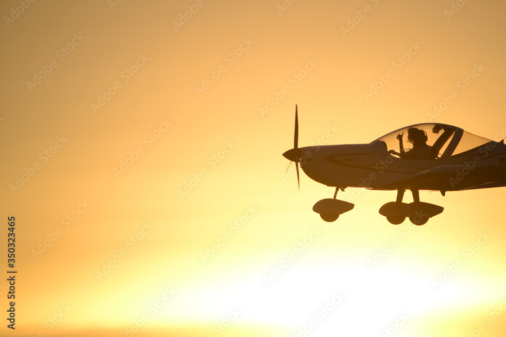 Fototapeta premium airplane at sunset flying, in air, pilot