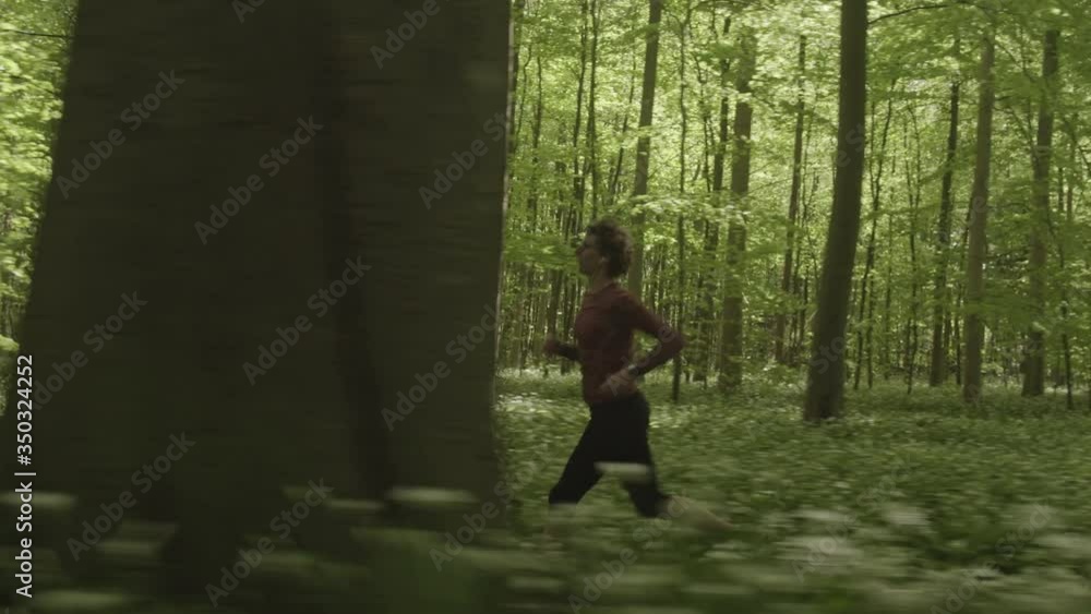 Woman Sprinting in the Woods as She Slightly Bends Her Head to Avoid Tree Branches Woman Sprinting in the Woods as She Slightly Bends Her Head to Avoid Tree Branches