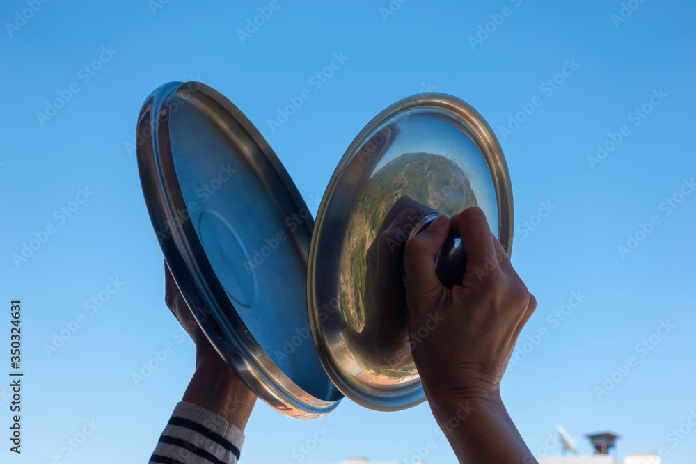 Woman hands banging pot lids against blue sky. Protest against the  government measures. Banging pots and pans from the windows and balcony  Stock Photo | Adobe Stock