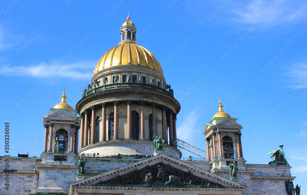 Facade and colonnade with golden dome of Saint Isaac's Cathedral in Saint Petersburg, Russia. Historic orthodox church, majestic active cathedral outdoor architeture