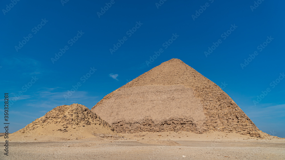 The Bent Pyramid is an ancient Egyptian pyramid located at the royal necropolis of Dahshur, approximately 40 kilometres south of Cairo, built under the Old Kingdom Pharaoh Sneferu. Egypt The Bent Pyramid is an ancient Egyptian pyramid located at the royal necropolis of Dahshur, approximately 40 kilometres south of Cairo, built under the Old Kingdom Pharaoh Sneferu. Egypt