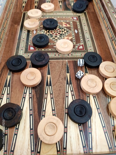 Backgammon with wooden inlay. Wooden backgammon board game of pearl inlaid on brown background. photo