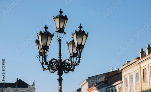 An old beautiful lantern in the historical center of Lviv on blue sky background. The concept of spring city. © shchus