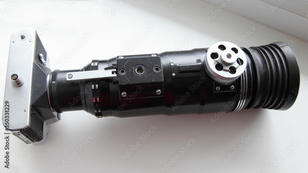 Retro Soviet Photo gun closeup bottom view - SLR film camera with large telephoto lens on white background Retro Soviet Photo gun closeup bottom view - SLR film camera with large telephoto lens on white background