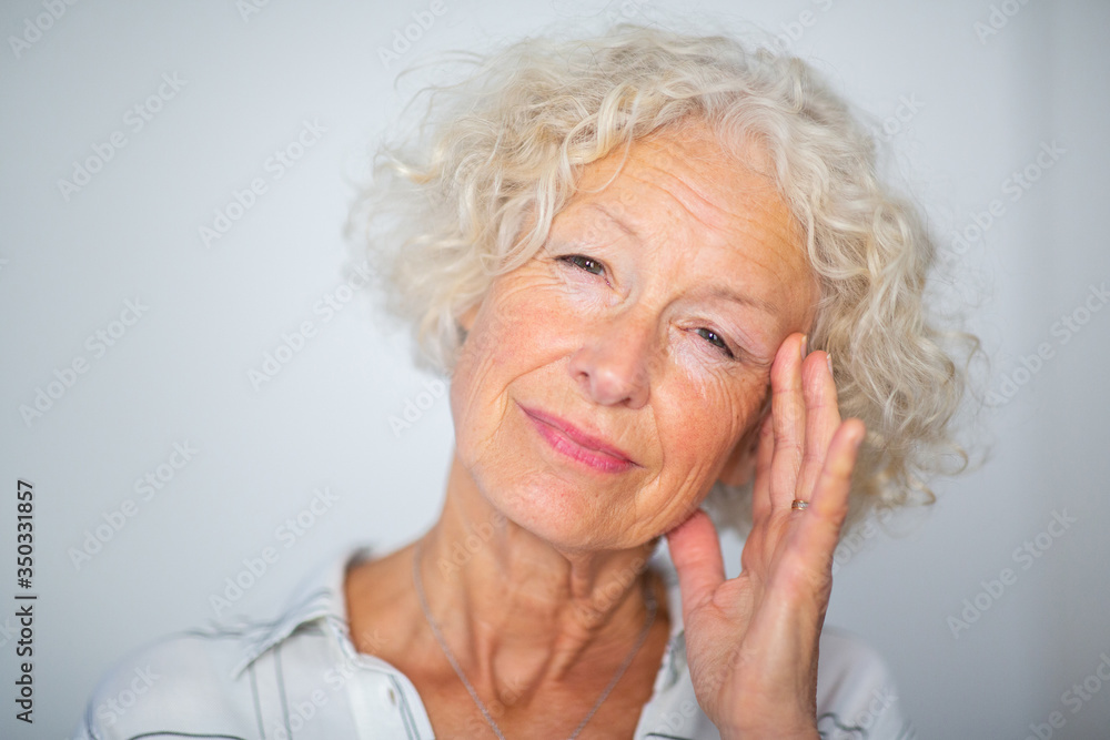 Close up elderly woman with headache and hand to head Close up elderly woman with headache and hand to head