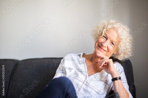 happy older woman relaxing on couch at home