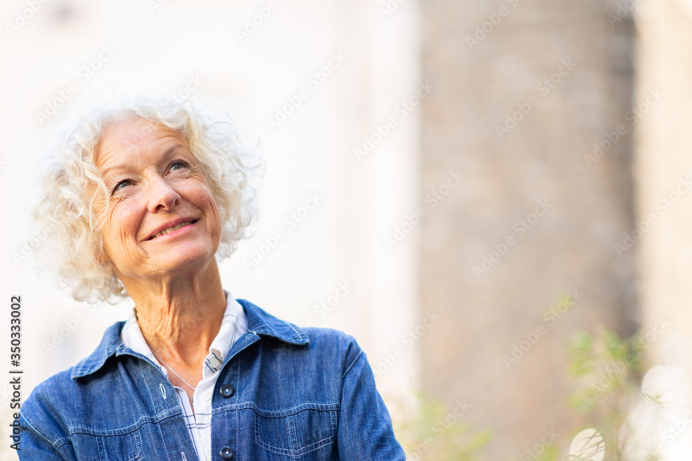 Close up smiling elderly woman looking up Close up smiling elderly woman looking up