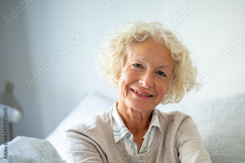 Close up happy elderly woman relaxing at home © mimagephotos