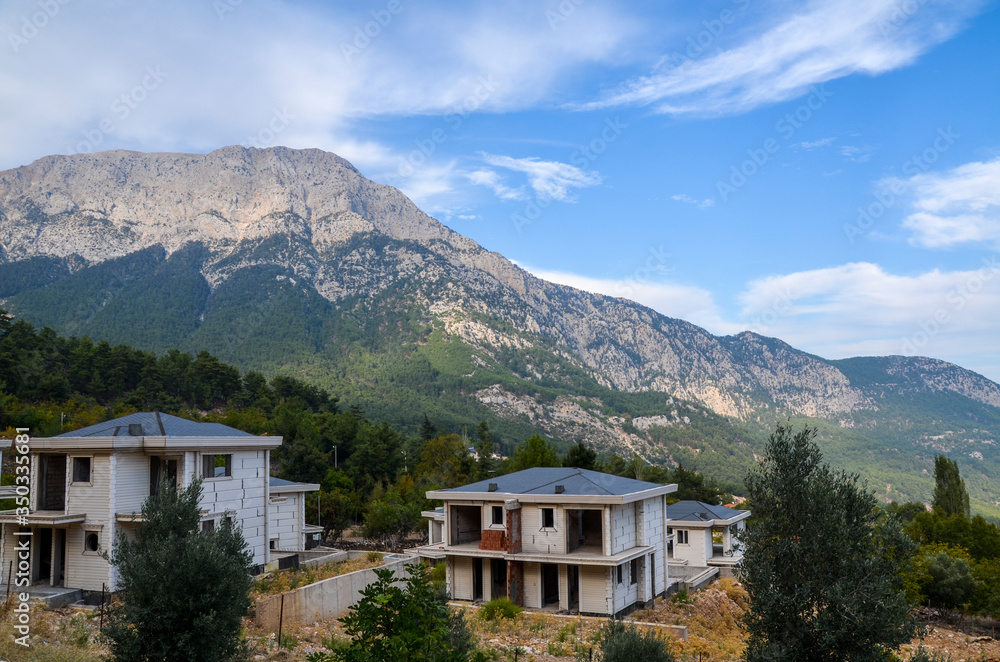Unfinished houses with mountain background behind with clouds on the sky, Turkey