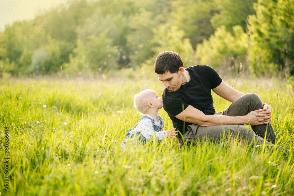 Father's day. A man and his daughter enjoy a vacation in a green park or forest in the warm rays of the sun, experiencing family joy. Father's day. A man and his daughter enjoy a vacation in a green park or forest in the warm rays of the sun, experiencing family joy.