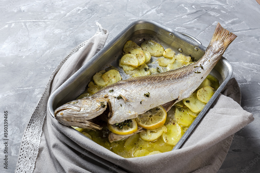 Fresh raw sea bass fish prepared for roasting with potatoes