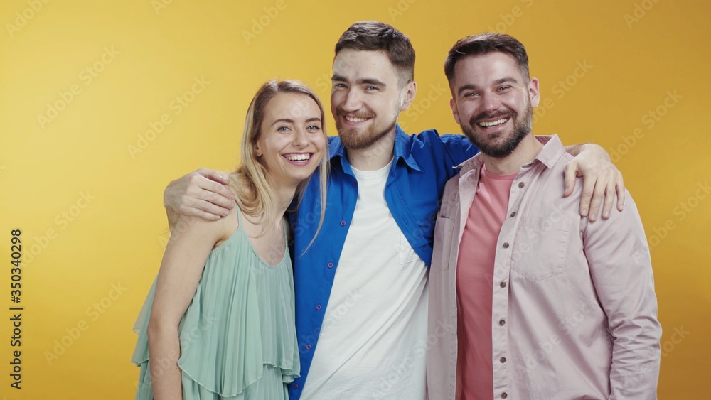 Hipster couple of two best friends brothers talking fun communication on background. Happy blonde girl hugs her friends men enjoying time together. Friendship concept. Hipster couple of two best friends brothers talking fun communication on background. Happy blonde girl hugs her friends men enjoying time together. Friendship concept.