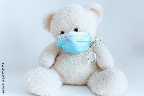 soft toy in a medical mask on a white background © Ann