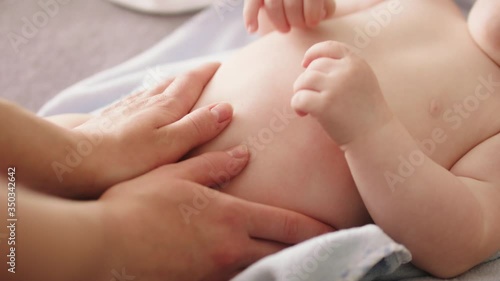 Wallpaper Mural Mother massaging baby tummy. Baby skin care and development concept. Torontodigital.ca