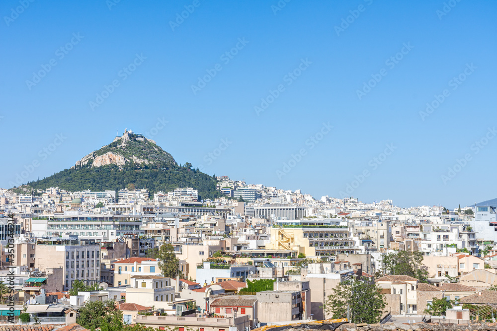 View of the city of Athens and the Lycabettus hill on a summer day with a blue sky