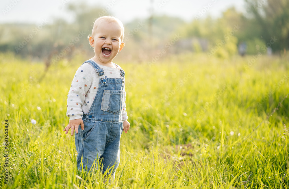 Summer children's walks. The child experiences emotions of joy in the forest on a meadow on a sunny day. Summer children's walks. The child experiences emotions of joy in the forest on a meadow on a sunny day.