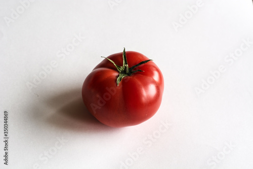 Red tomato lying on a white background