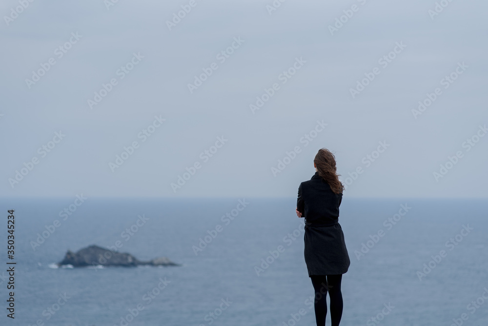 young woman standing against a blue sky and sea young woman standing against a blue sky and sea