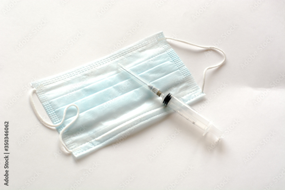 medical mask and syringe.lying on a white background medical mask and syringe.lying on a white background