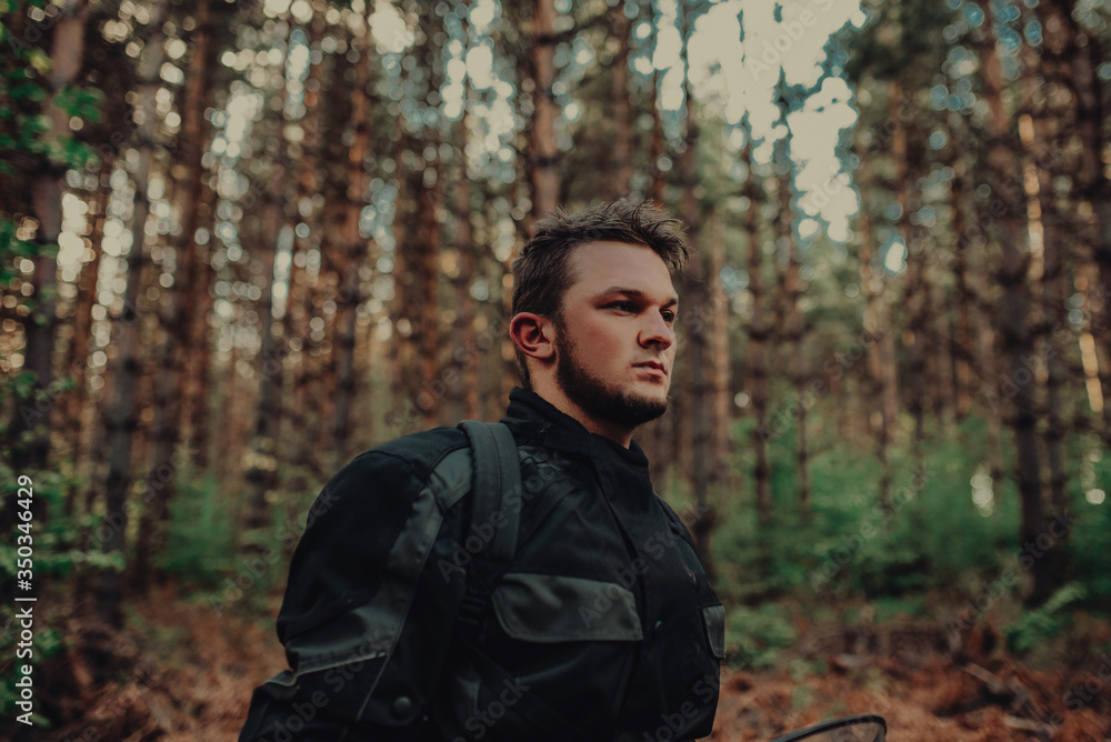 portrait of young happy man enjoying beautiful sunny day taking a break from driving a quad,atv in forest portrait of young happy man enjoying beautiful sunny day taking a break from driving a quad,atv in forest