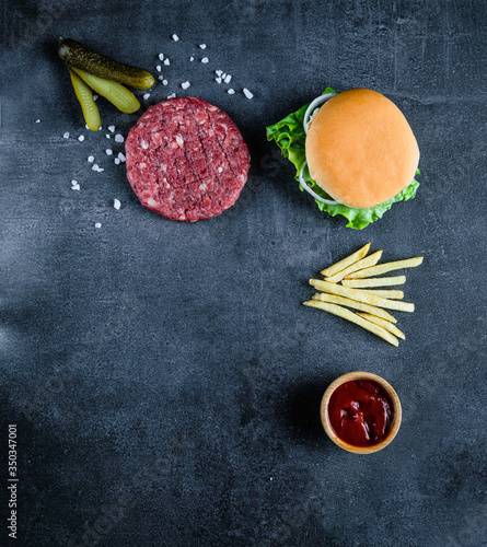 Fototapeta Naklejka Na Ścianę i Meble -  Red burger meat closeup on black background. Top view. Food preparation.