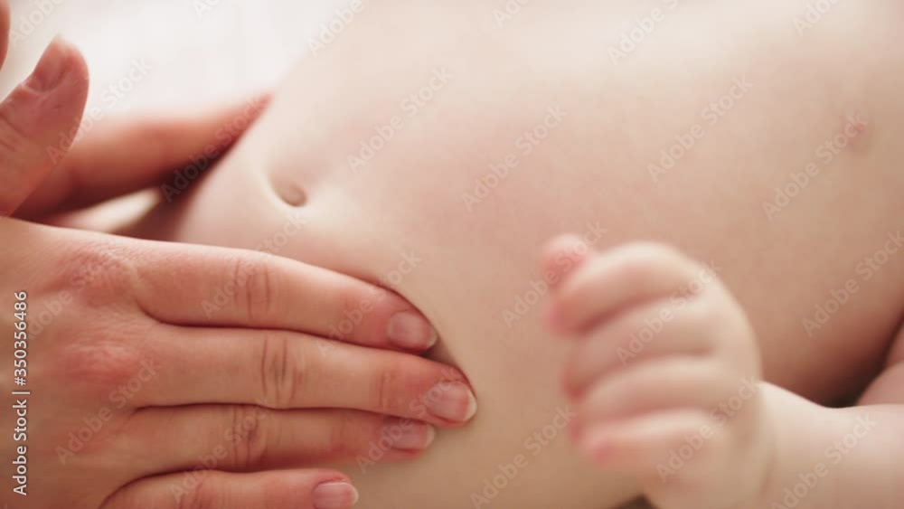 Mother massaging baby tummy. Baby skin care and development concept. Mother massaging baby tummy. Baby skin care and development concept.