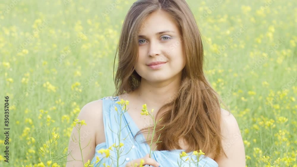 smiling beautiful romantic girl on blooming rapeseed field enjoying nature, young elegant woman walks, holiday mood smiling beautiful romantic girl on blooming rapeseed field enjoying nature, young elegant woman walks, holiday mood