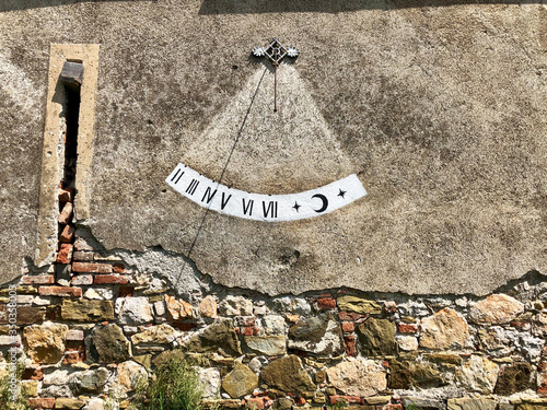 Sundial clock on old broken concrete wall photo