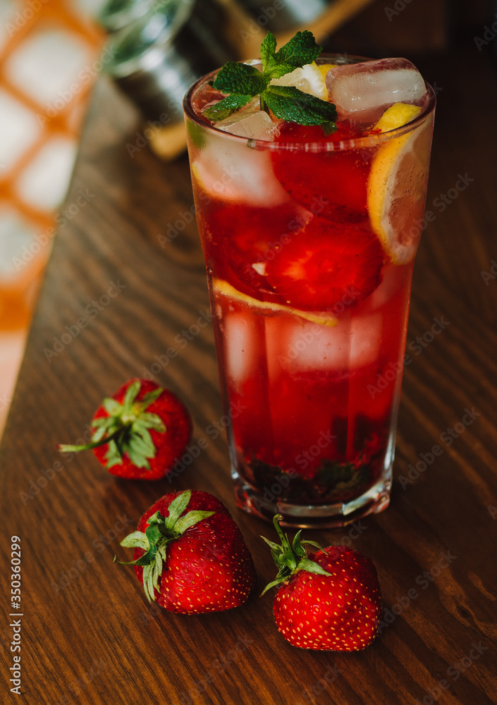 Fresh cold lemonade with strawberries and lemon on wooden background. Citric, healthy Fresh cold lemonade with strawberries and lemon on wooden background. Citric, healthy