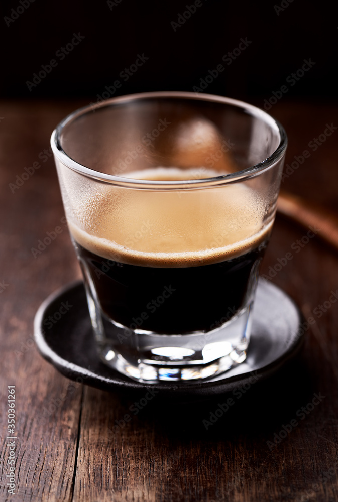 Coffee in glass cup on rustic wooden background. Close up. Coffee in glass cup on rustic wooden background. Close up.