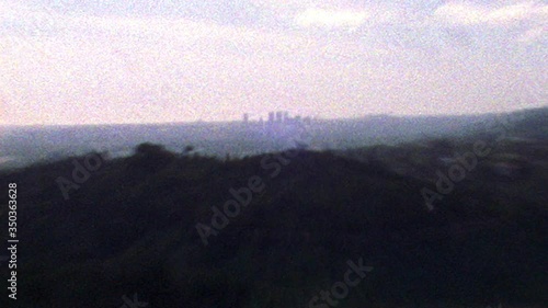 Shaky old looking archival footage of Los Angeles skyline and hills in the distance