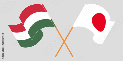 Crossed and waving flags of Hungary and Japan