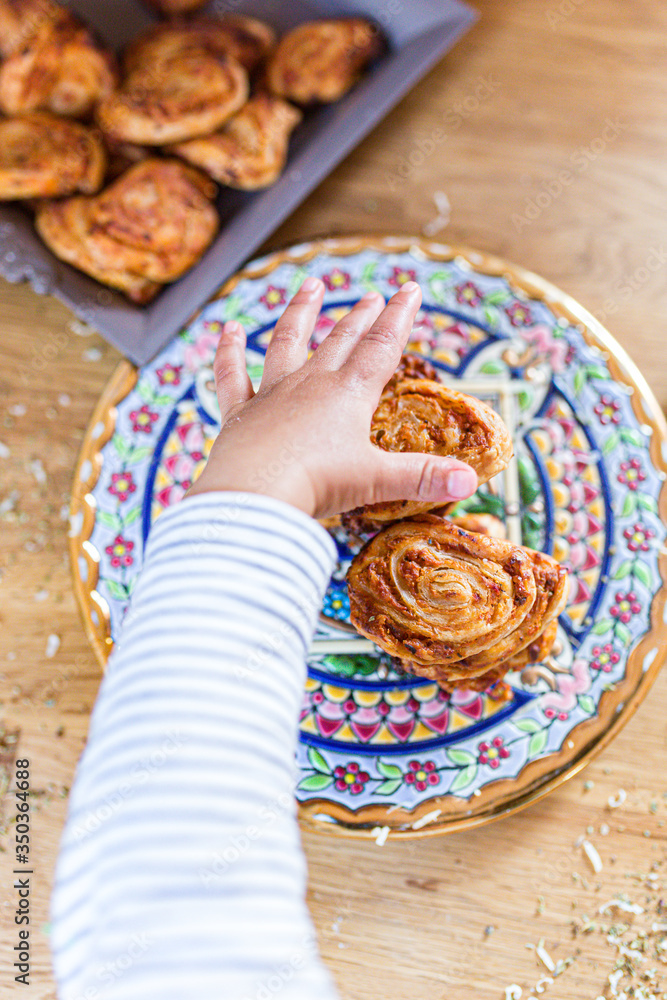 tomato and cheese roll on oriental plate with a baby-hand tomato and cheese roll on oriental plate with a baby-hand