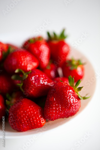 Close up. Fresh ripe delicious strawberries in a white bowl isolated on white background. Beautiful Italian red strawberry. European eco food without pesticides and additives in Milan  Lombardy  Italy