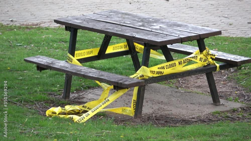 Yellow tape with Park Closed sign tied around a park bench and table due to Covid-19 pandemic
Yellow tape with Park Closed sign tied around a park bench and table due to Covid-19 pandemic
