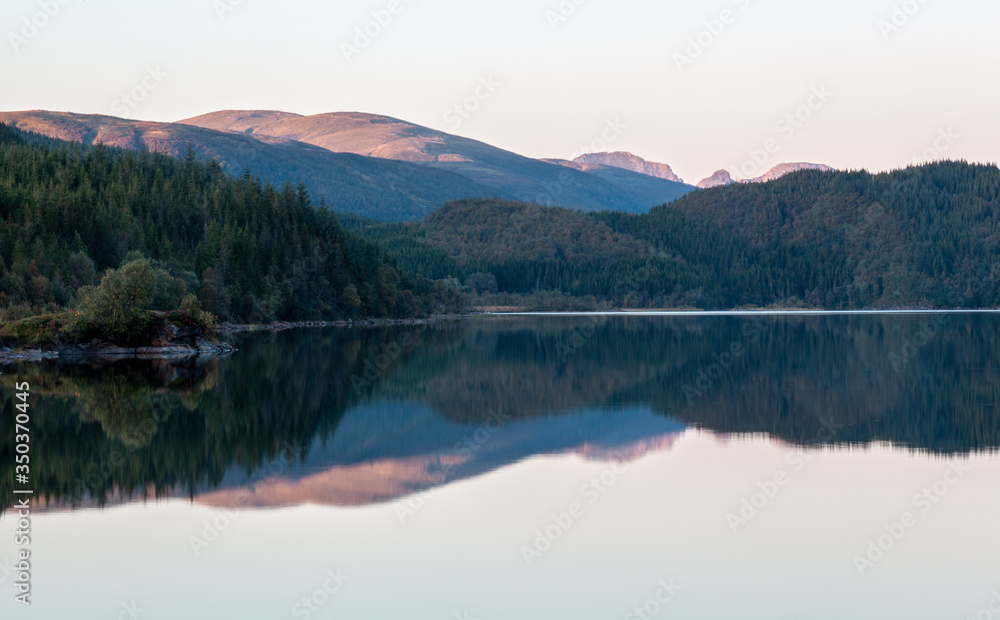 The reflection of the hills and woods in the lake.