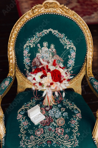 Bridal bouquet on a vintage armchair  shades of red, green, white with very beautiful colors, dear color. Мintage armchair with a golden hue