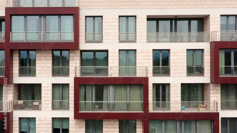 Exterior of a high-rise multi-story residential apartment building - facade, windows and balconies. Establishing shot aerial footage. Exterior of a high-rise multi-story residential apartment building - facade, windows and balconies. Establishing shot aerial footage.