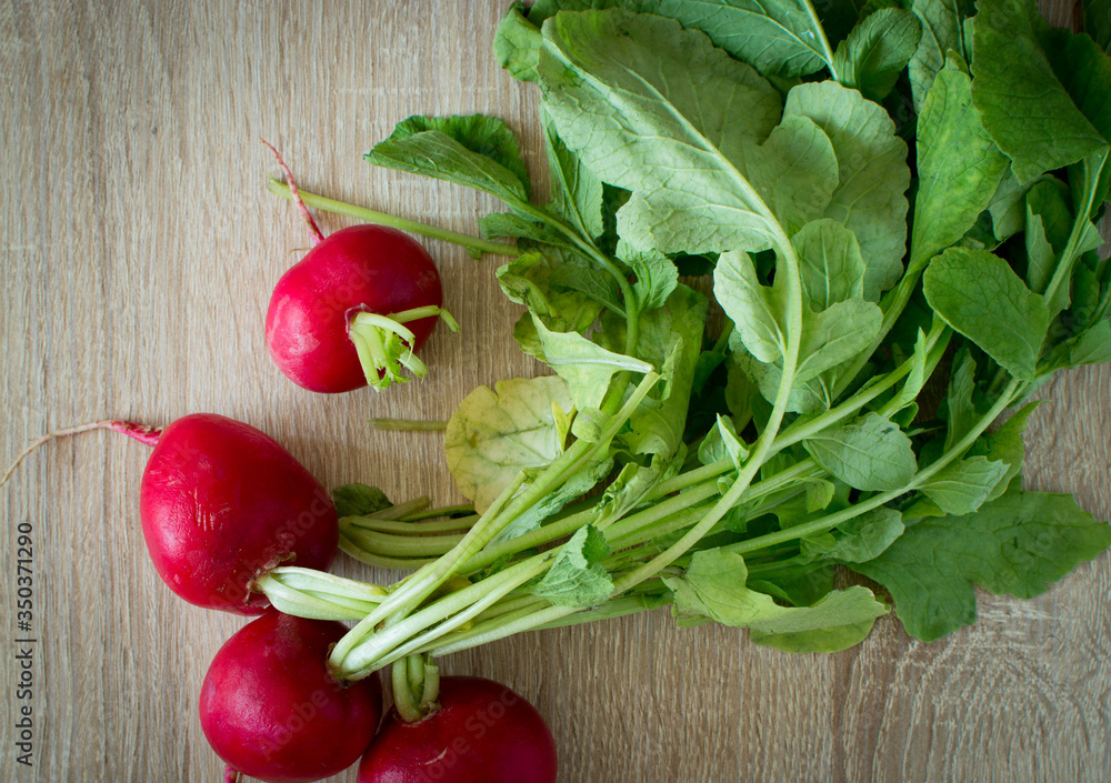 Spring healthy meal with vegetables. Red radishes on wooden table, rustic effect. Spring healthy meal with vegetables. Red radishes on wooden table, rustic effect.