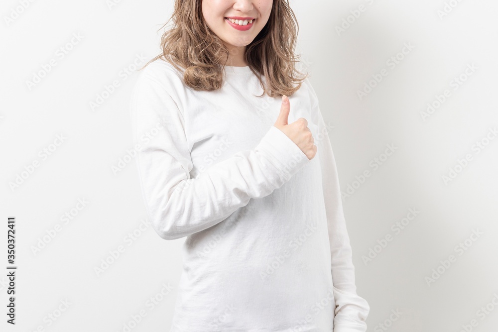 いいねのポーズをする若い女性 いいねのポーズをする若い女性