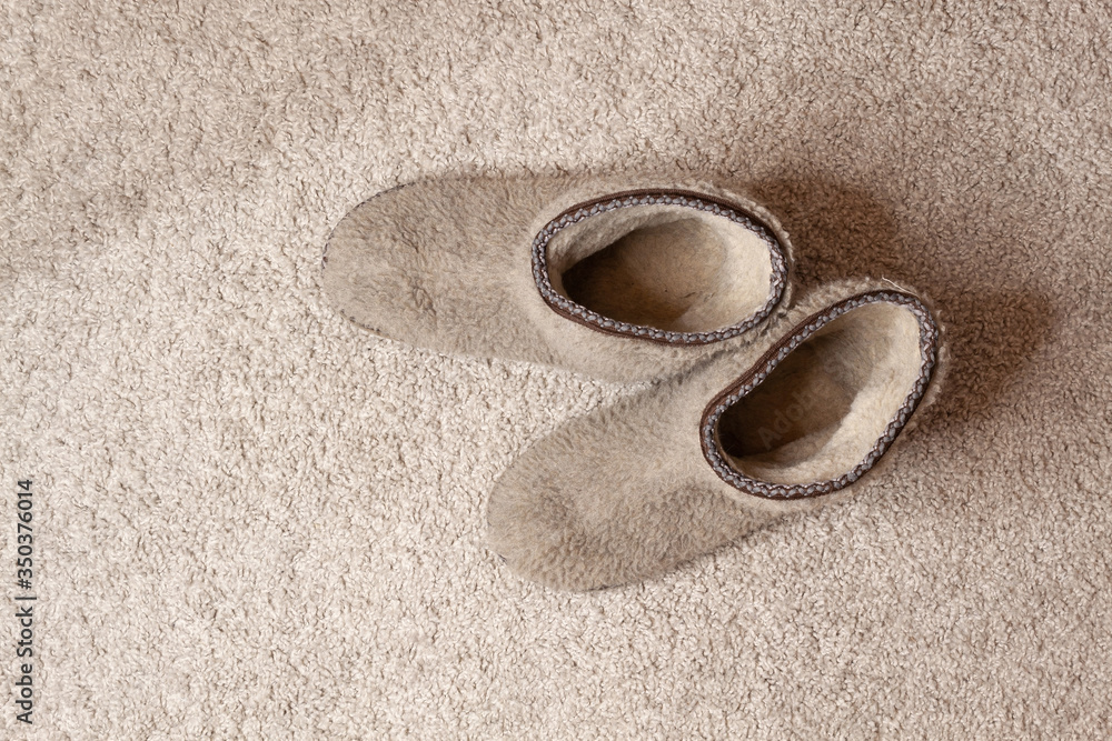 Obraz premium Carpet texture. Soft cozy slippers at beige carpet floor 