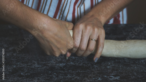 Manos de mujer casada amasando para hacer pan casero durante la cuarentena.
