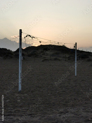 net for beach volleyball on the background of an empty beach and sunset